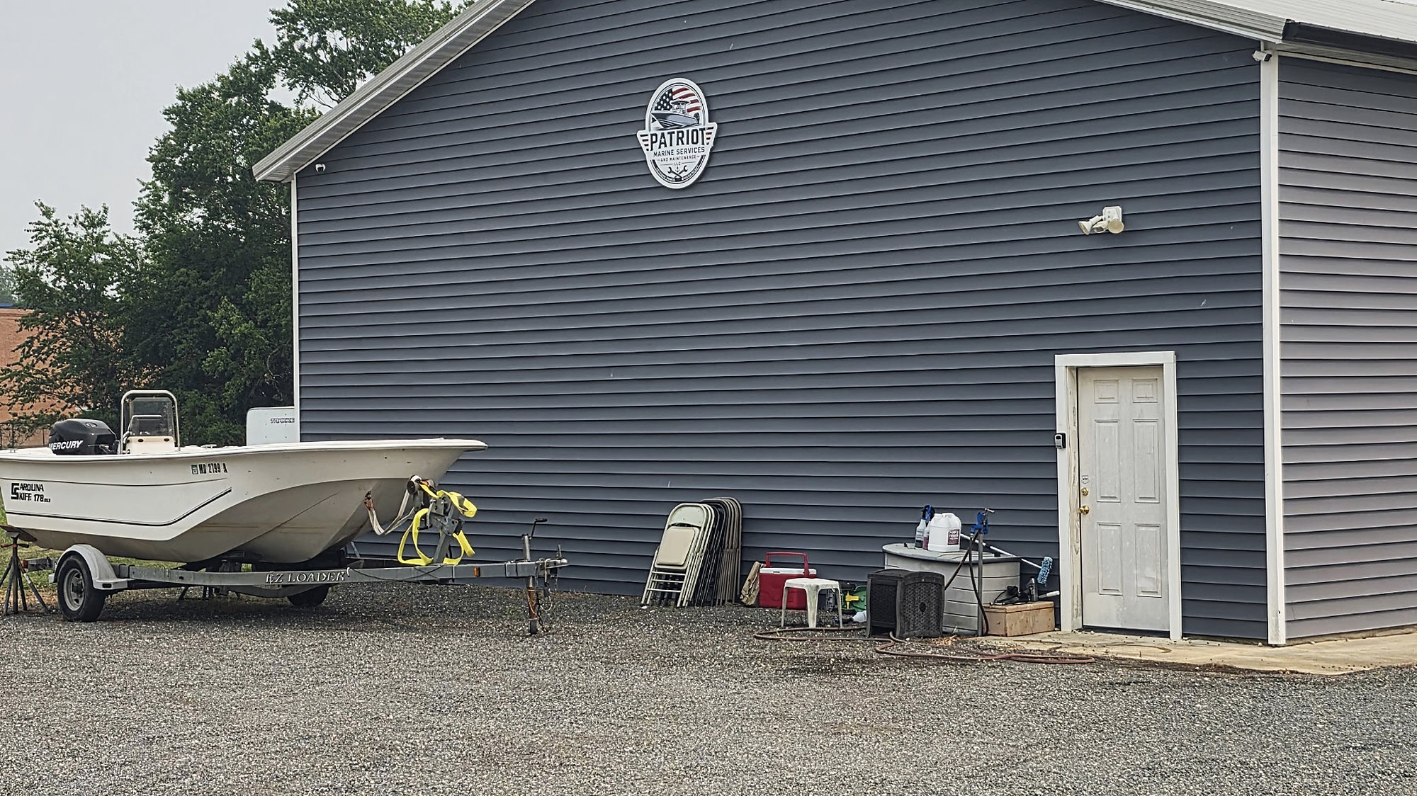 The Patriot Marine shop in Ridgely, a boat on its trailer beside it and the gravel yard
