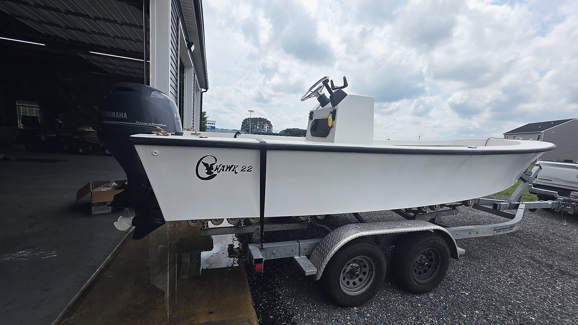 A Hawk 22 center console on its trailer beside the open door of the Patriot Marine shop in Ridgely