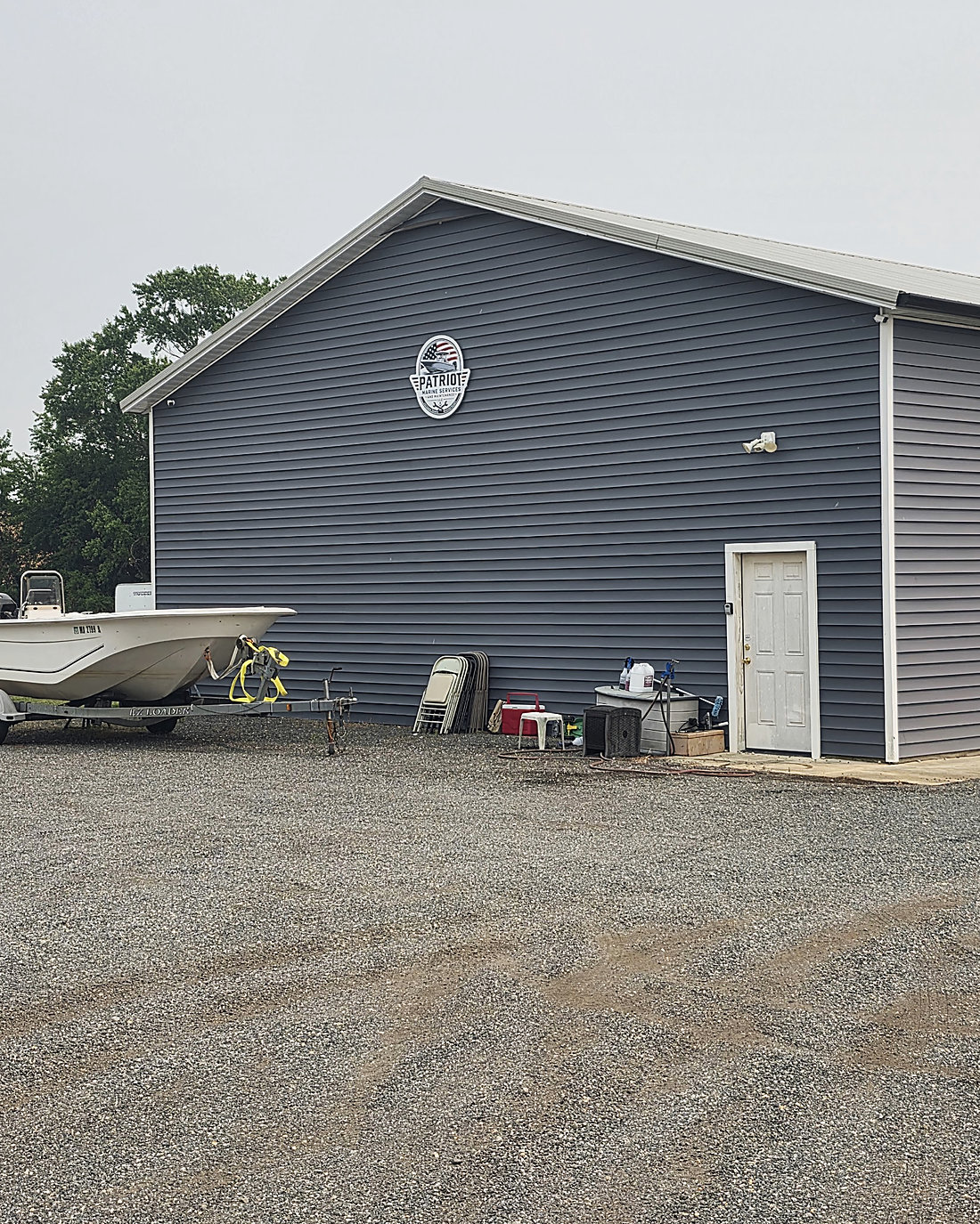 The Patriot Marine shop in Ridgely: a grey pole barn with a gravel lot