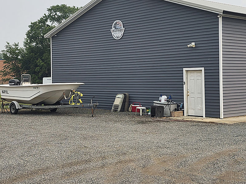 The Patriot Marine shop, a grey pole barn with a gravel lot